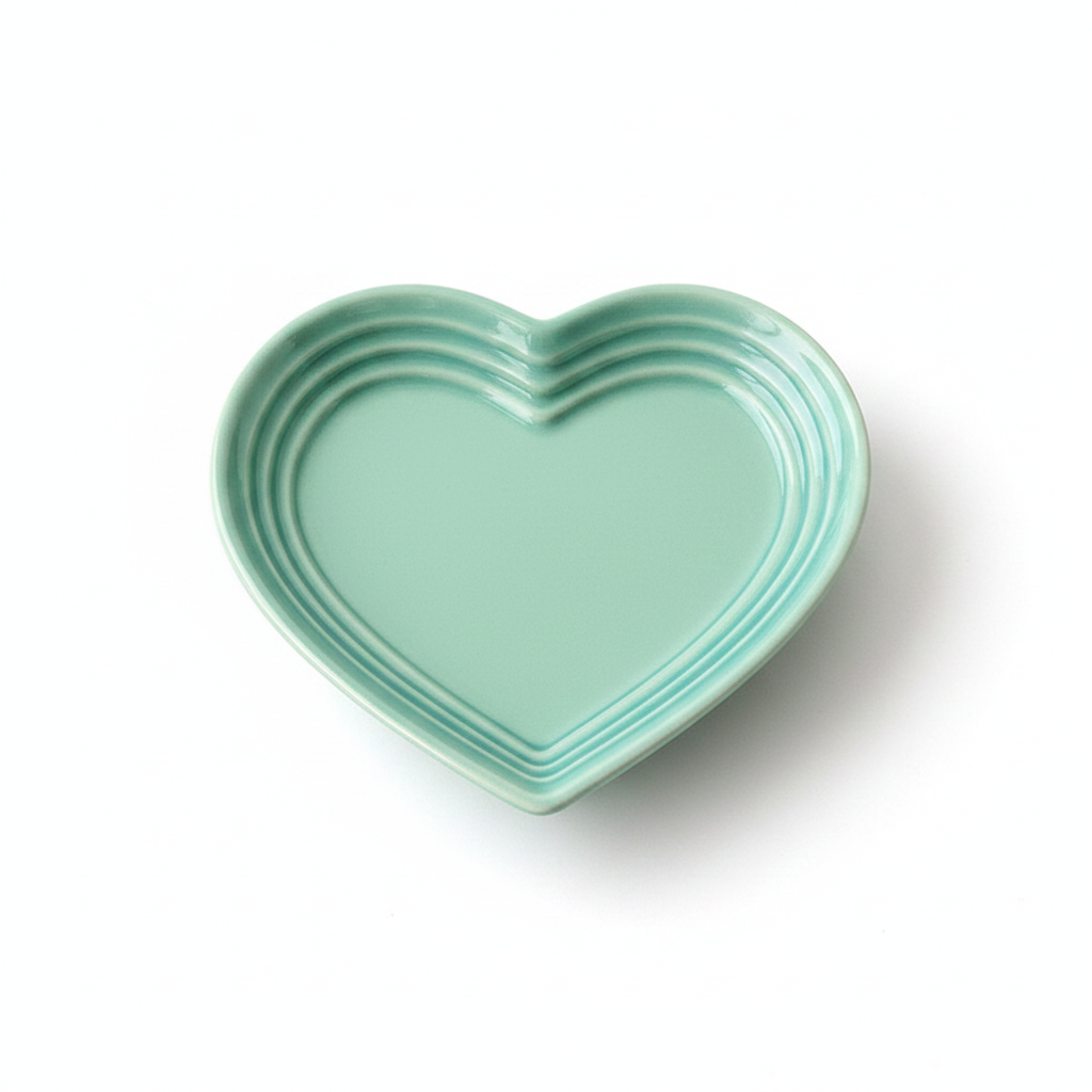 Mint teal heart-shaped ceramic cat bowl with ridged rim and “LE CREUSET” mark