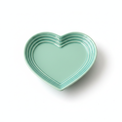 Mint teal heart-shaped ceramic cat bowl with ridged rim and “LE CREUSET” mark